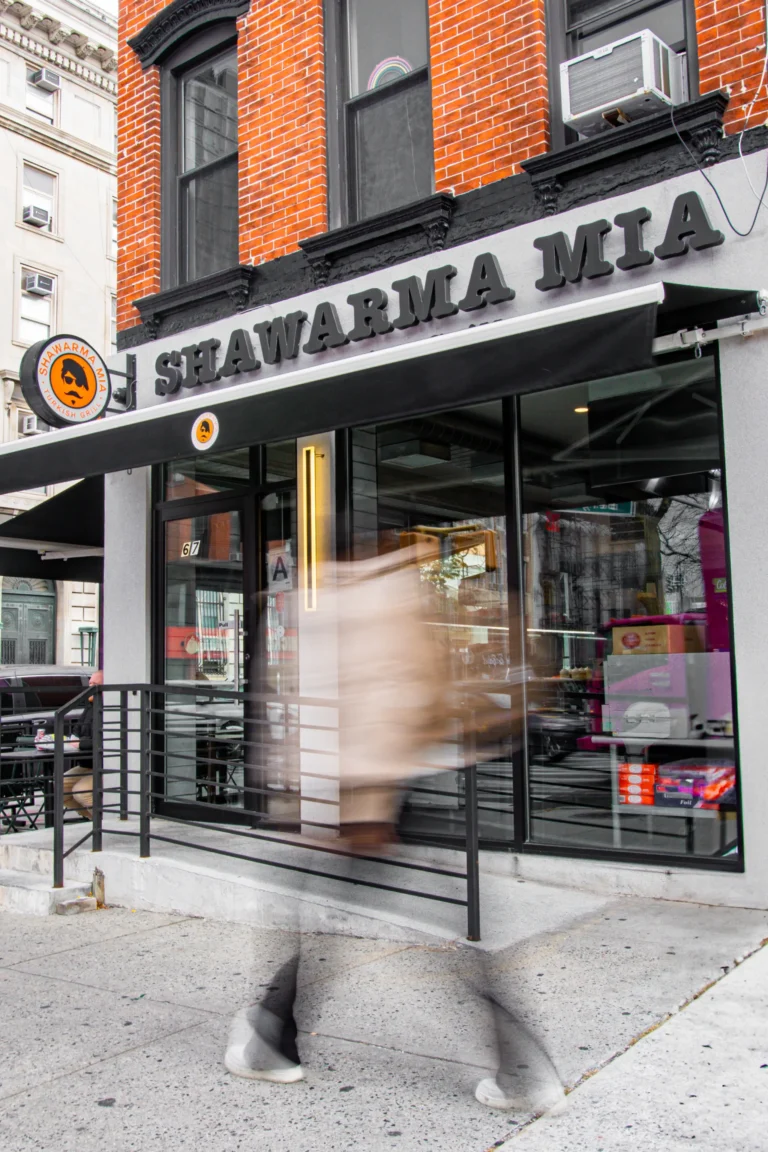 Shawarma Mia Turkish Grill storefront with signage and a passerby walking by on the sidewalk