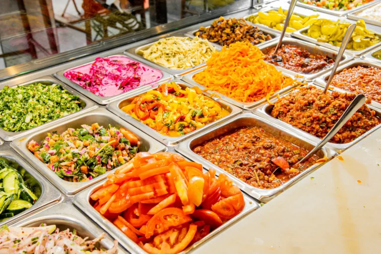 Fresh salad and topping bar with tabbouleh, red cabbage, carrots, tomatoes, pickles and spreads