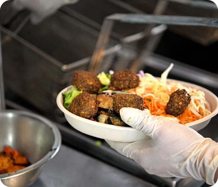 Falafel bowl with fresh salad, shredded carrots and cabbage served fresh from the fryer