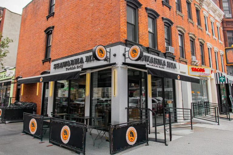 Shawarma Mia Turkish Grill corner storefront on a brick building with outdoor seating and awnings